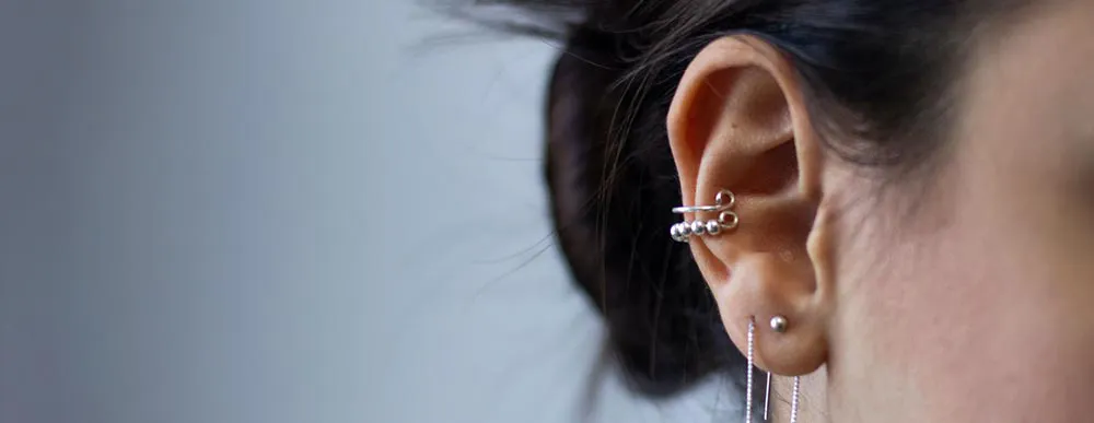 Woman's ear with three piercings.