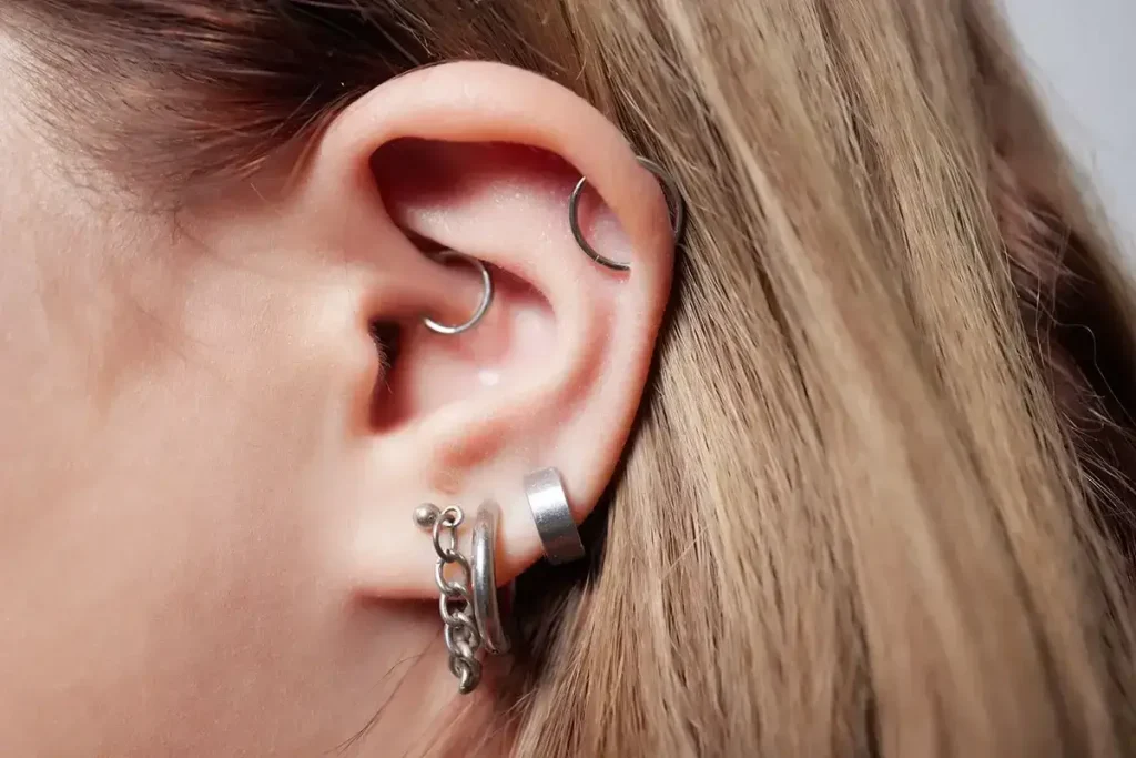 Someone's ear with lots of piercings.