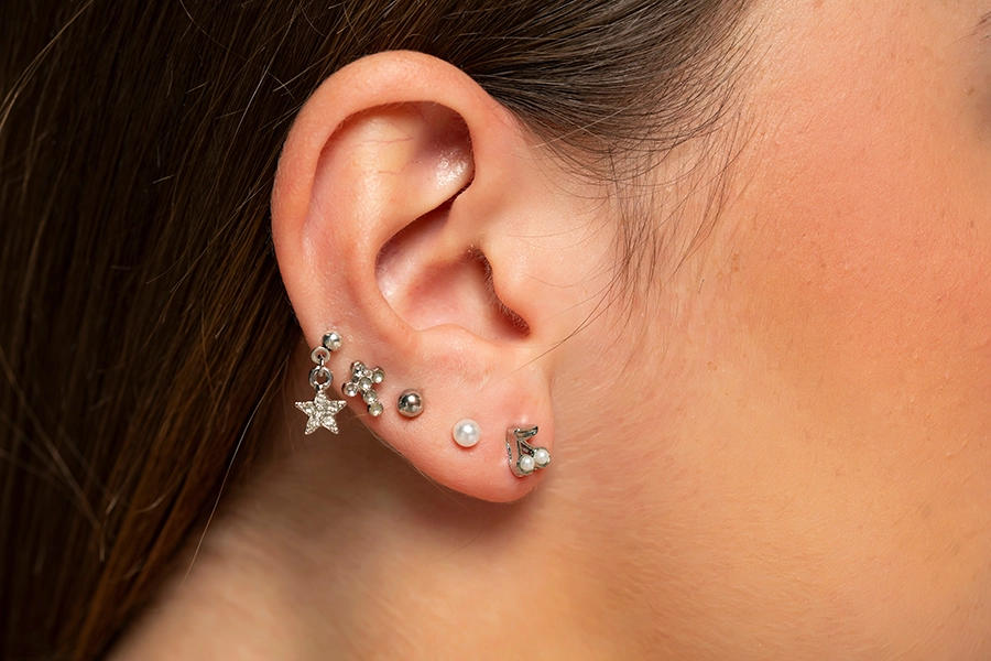 Five piercing in a woman's earlobe.